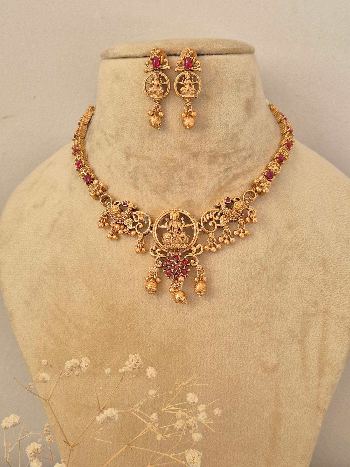Gold-toned ethnic choker necklace with stone detailing and matching earrings by naitri.in