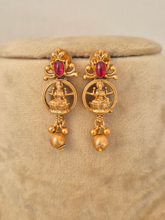 Handcrafted gold-toned drop earrings featuring intricate goddess with stone embellishments by naitri.in