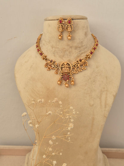 Handcrafted gold-toned choker necklace set featuring intricate stone embellishments, matching drop earrings by naitri.in