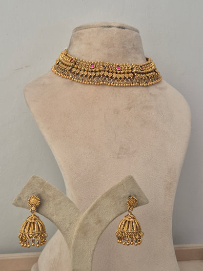 Gold antique choker necklace with pink stone highlights and matching jhumka earrings Traditional gold choker necklace and matching jhumka earrings set by naitri.in 