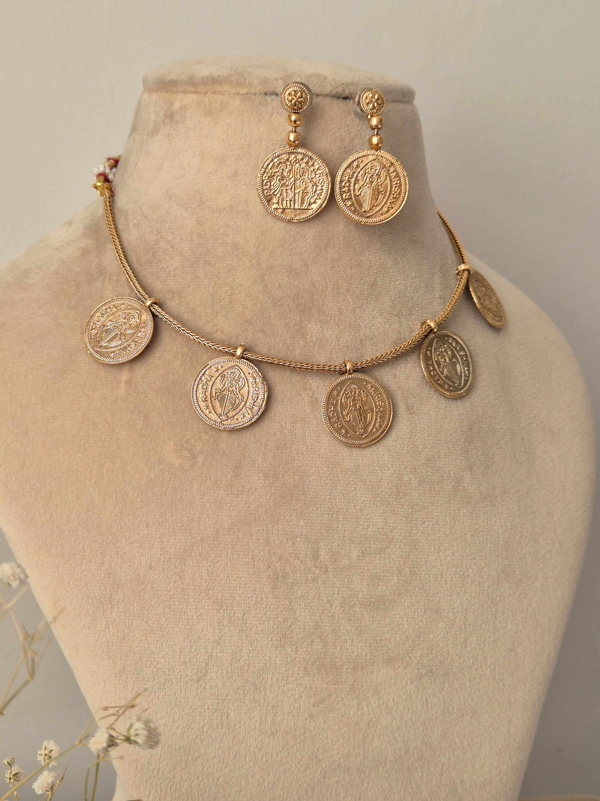 temple jewelry coin necklace with matte gold finish, featuring Radha-Krishna coins and a large matching pendants at the center by naitri.in
