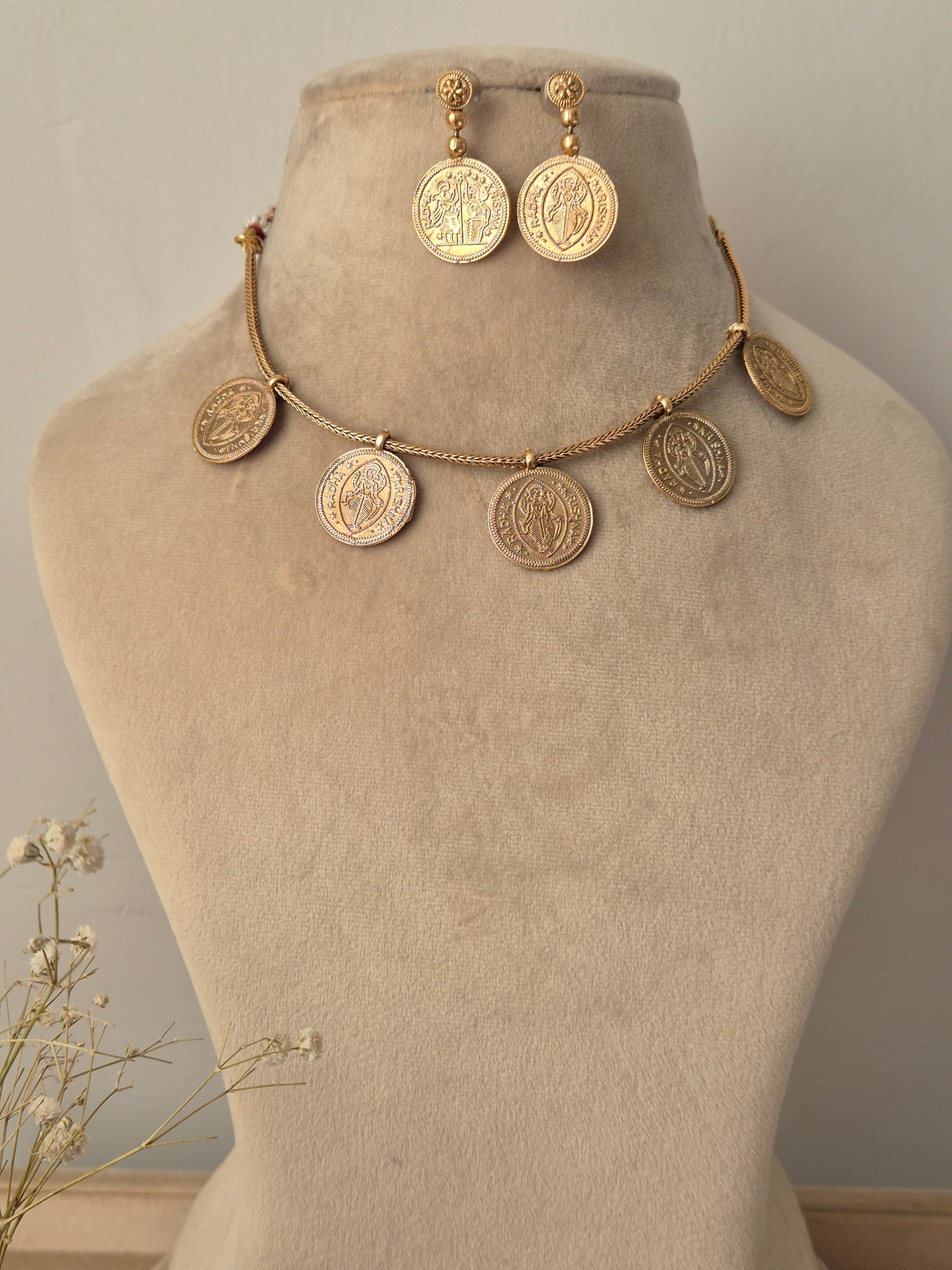 Minimalist brushed gold coin necklace with a subtle  Radha-Krishna and a high-polish finish by naitri.in