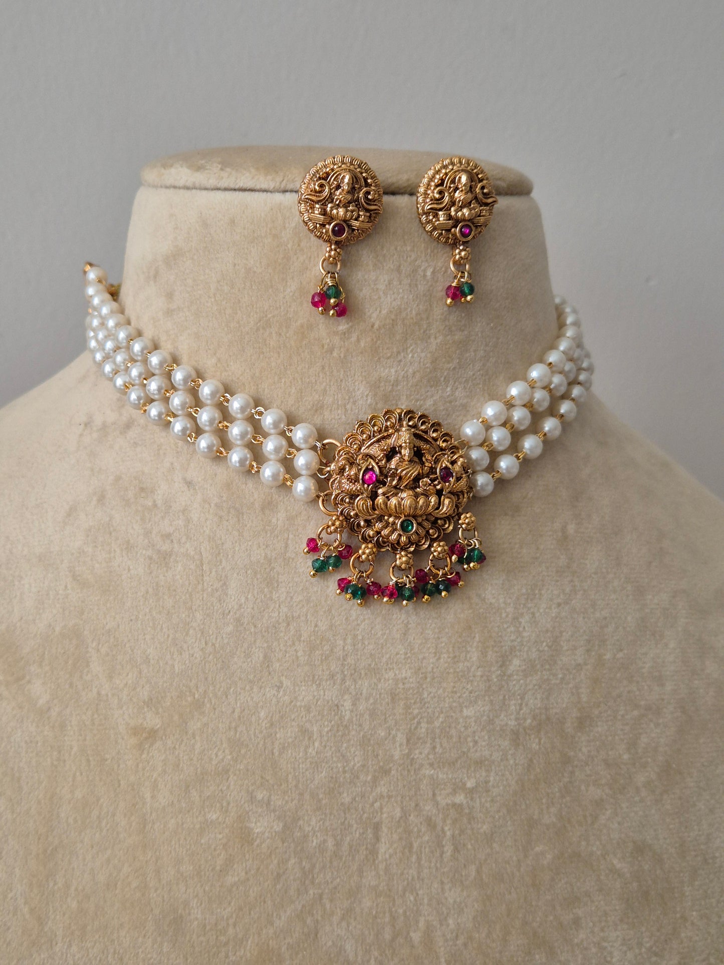 Set of gold jewelry with pearls chain Antique gold-plated choker necklace featuring a central Goddess Lakshmi motif, hanging colourful drops by naitri.in