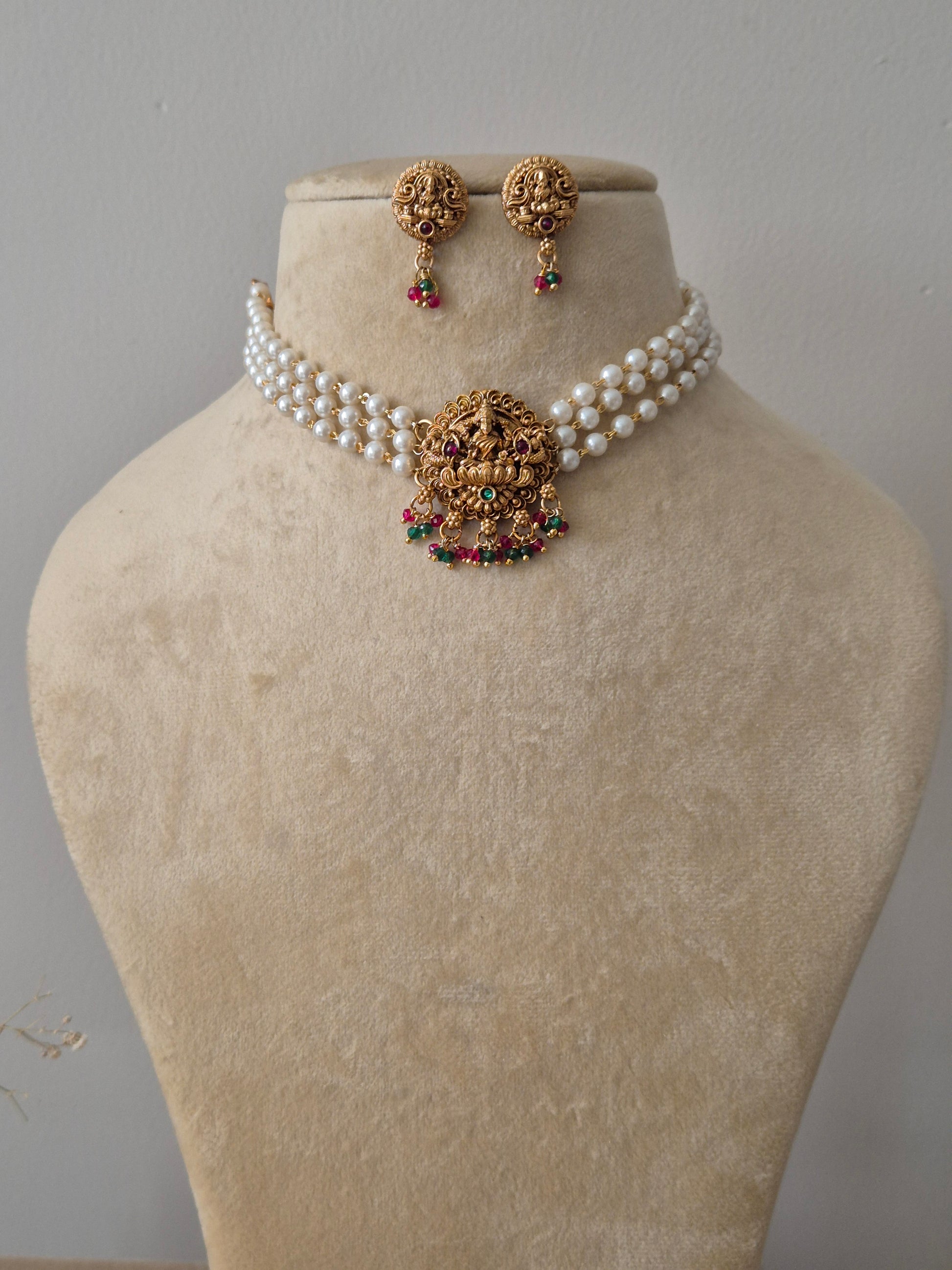 Set of gold jewelry with pearls chain, central motif representing purity and enlightenment, often used as a throne for the goddess by naitri.in