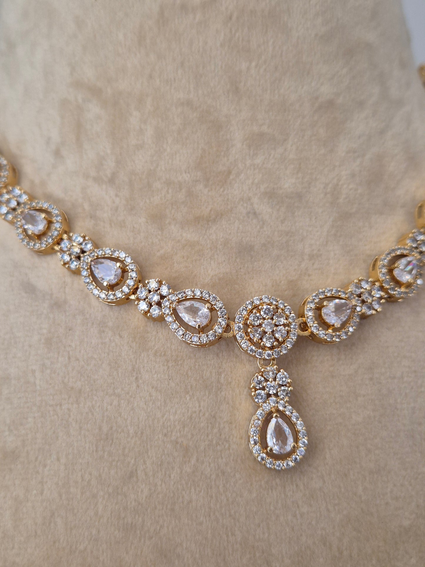  gold necklace with diamond-like stones Close-up of the Lisha Necklace Set from Naitri, featuring a delicate floral stone-studded design in brass alloy, by naitri.in