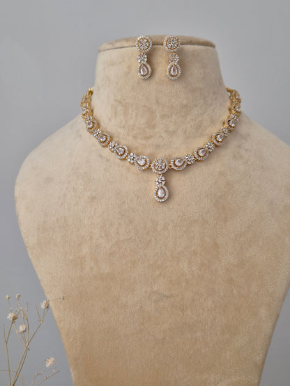 Gold-plated necklace set with intricate stone embellishments and matching stud earrings by naitri.in