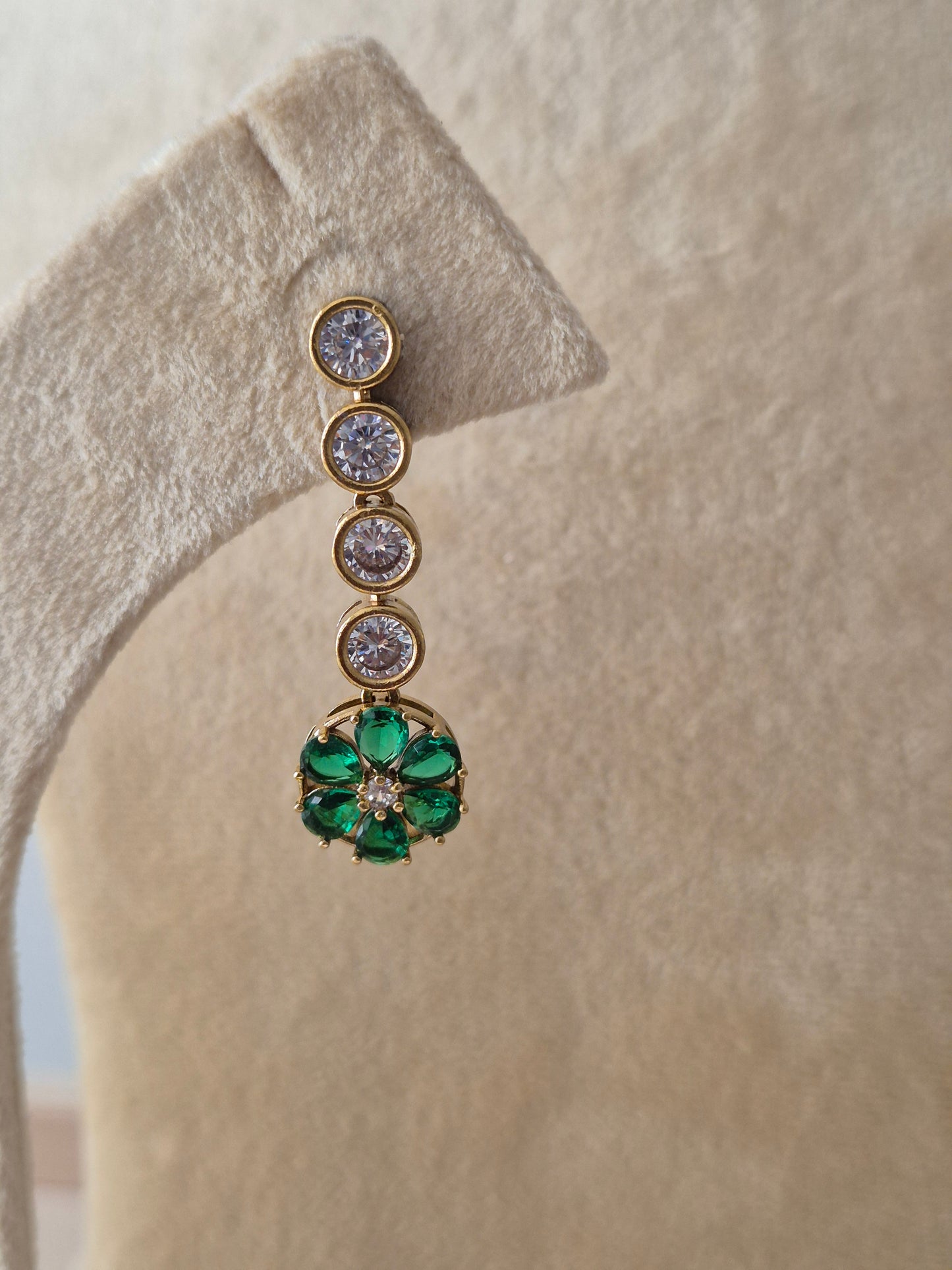 Gold-toned earrings with green gemstone flower motifs, featuring clear round stones by naitri.in