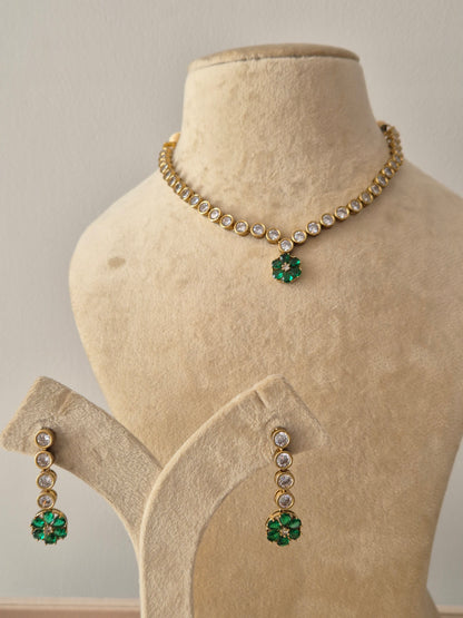 Necklace Set featuring a delicate gold-toned chain with white circular stones and a vibrant green floral pendant, including matching green flower drop earrings by naitri.in