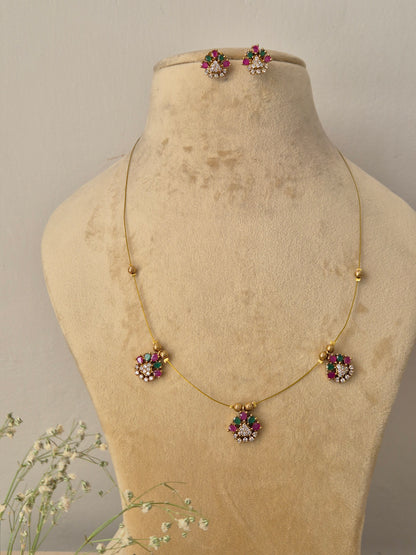 Delicate gold invisible chain necklace with small floral pendants and matching stud earrings by naitri.in