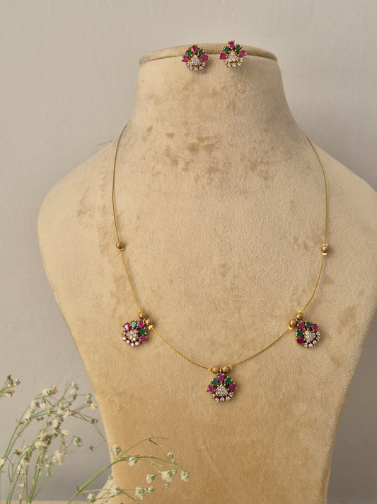 Delicate gold invisible chain necklace with small floral pendants and matching stud earrings by naitri.in