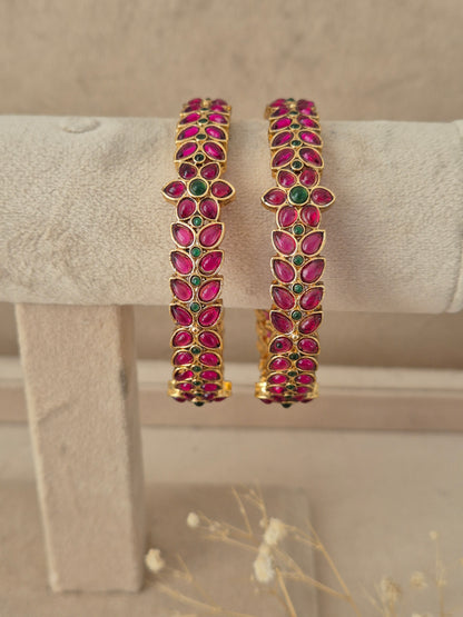Set of two pink and green stone-studded gold-plated bangles by naitri.in