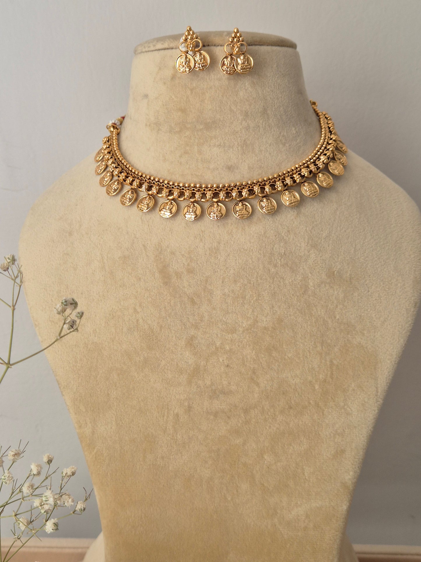  handcrafted gold-polished brass choker necklace featuring traditional coin charms with intricate temple design embossing and matching coin drop earrings by naitri.in