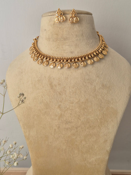  handcrafted gold-polished brass choker necklace featuring traditional coin charms with intricate temple design embossing and matching coin drop earrings by naitri.in
