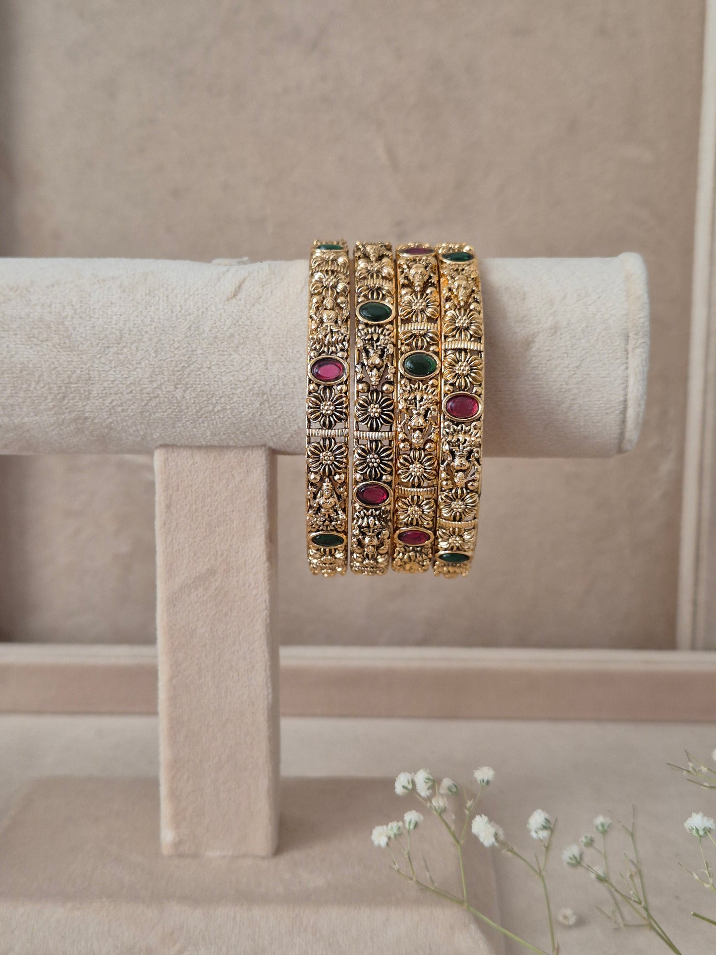 Set of gold bangles with gemstones by naitri.in