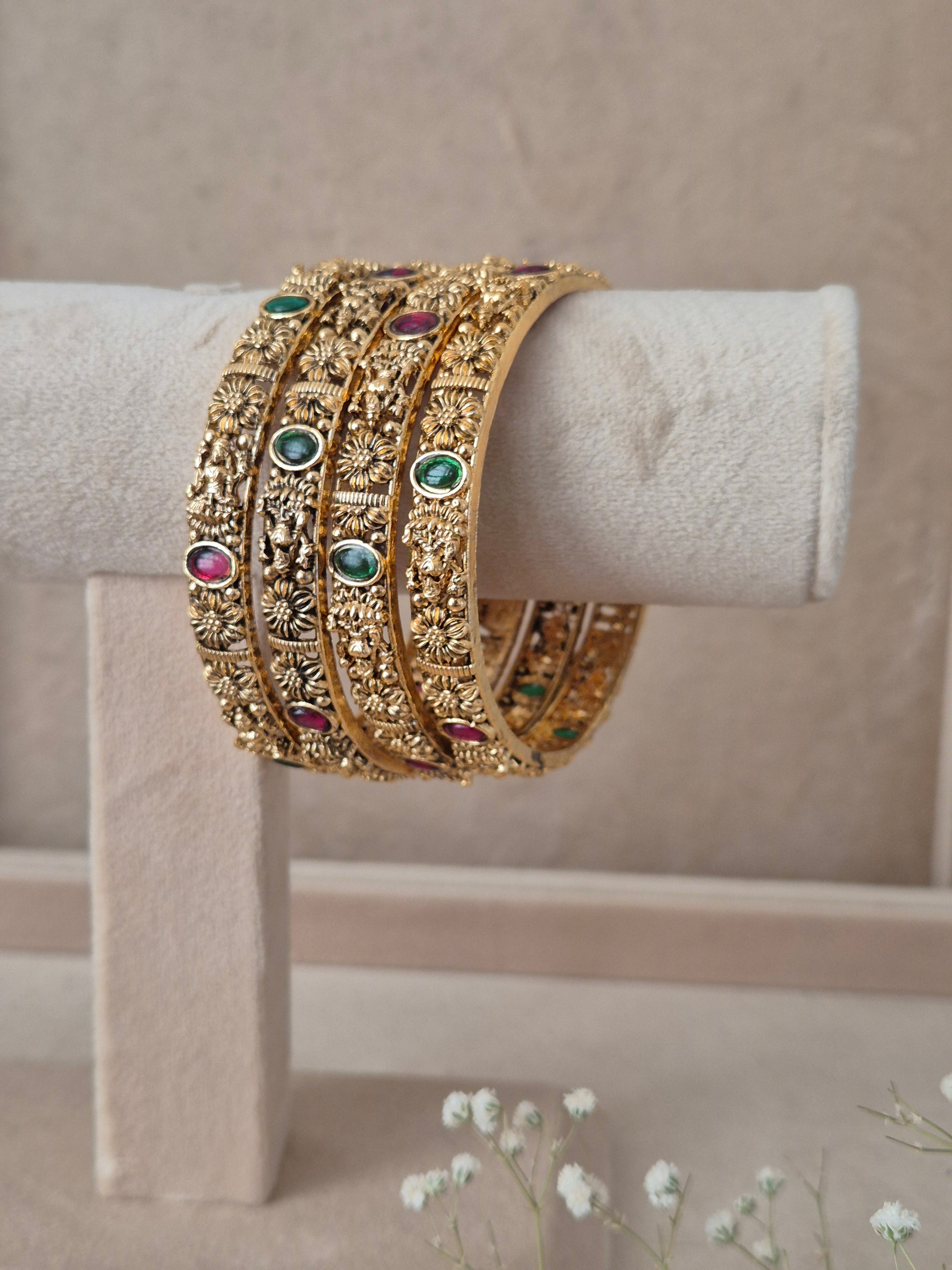 Festive style golden statement bangles with ethnic gemstone details by naitri.in