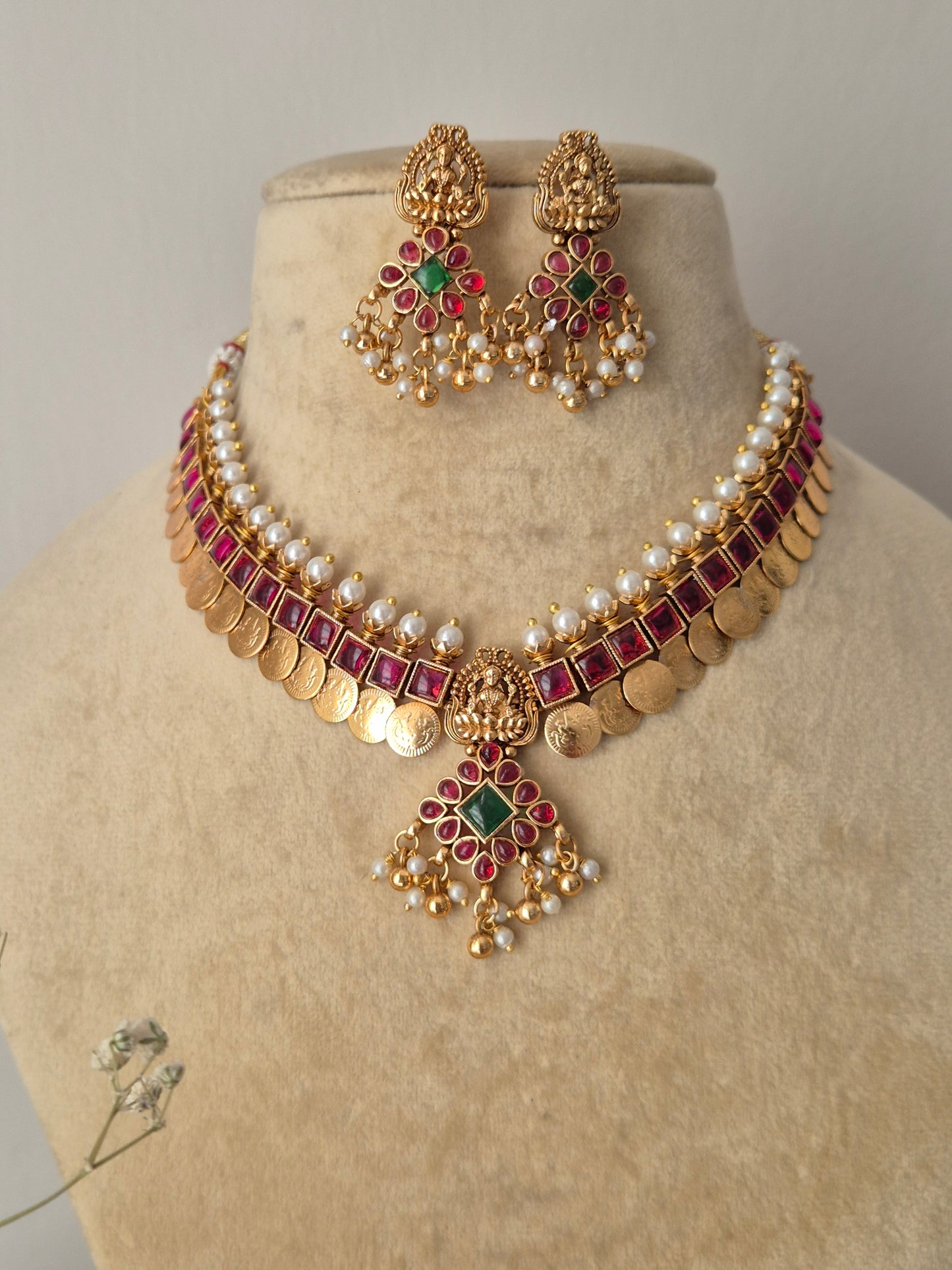 Gold-polished pearl and ruby-red stone choker with a dangling coin fringe and coordinating drop earrings from the Naitri collection by naitri.in