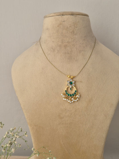 Handcrafted necklace featuring a gold-toned crescent moon pendant adorned with green stones, a central green emerald-like stone, and delicate white pearl droplets on a minimalist thin chain by naitri.in