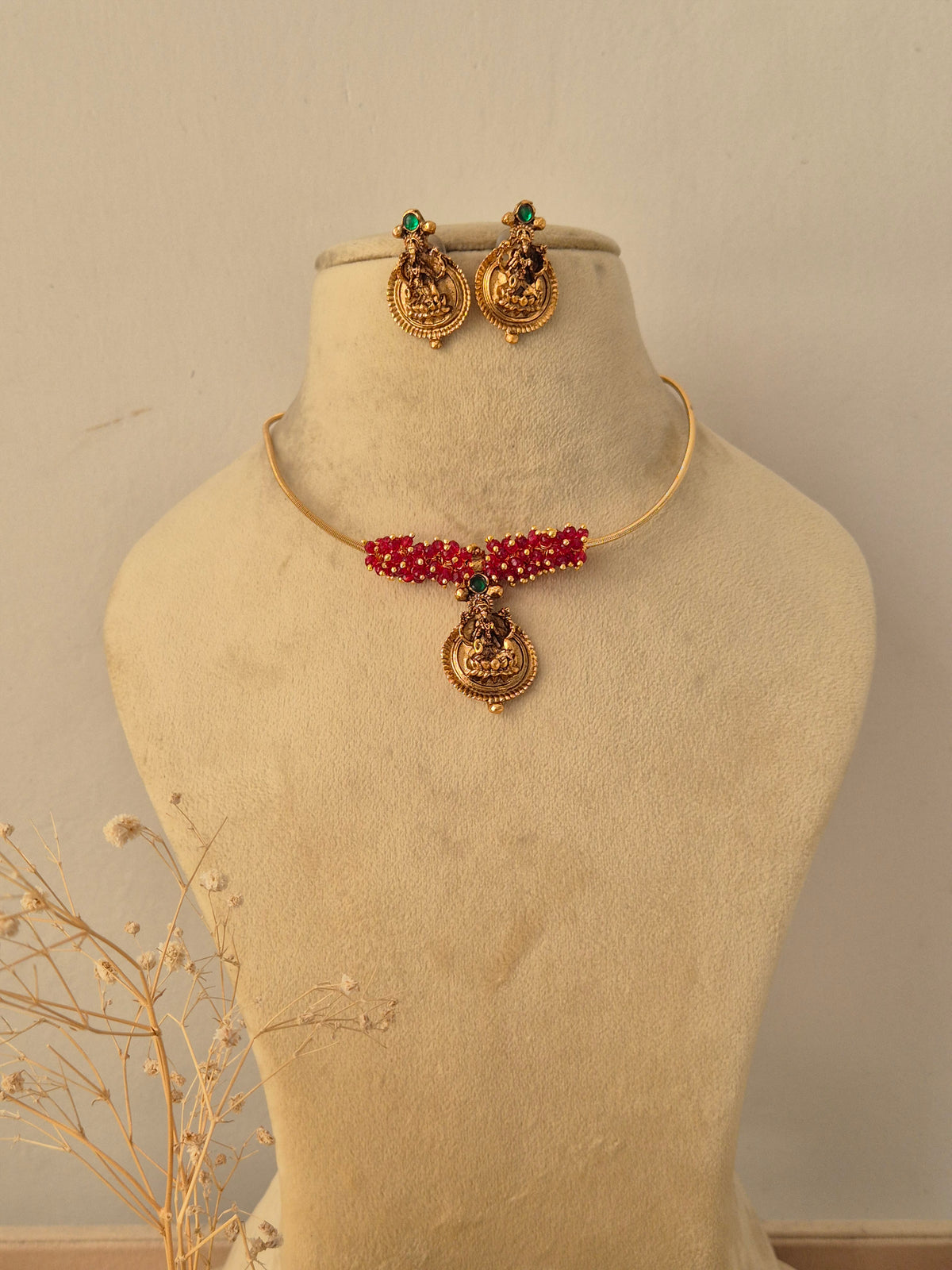 Traditional gold-plated ethnic necklace set with intricate red and green stone by Naitri.in