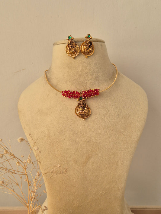 Traditional gold-plated ethnic necklace set with intricate red and green stone by Naitri.in