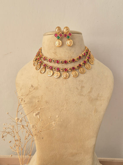 Mayra Necklace Set featuring traditional gold temple motifs with vibrant ruby and emerald stone accents and matching earrings by Naitri.in