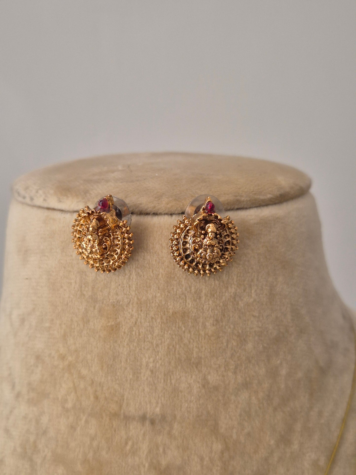 Traditional Indian-style Mayuri earrings in gold with small red stone, to showcase the modern ethnic  aesthetic by naitri.in