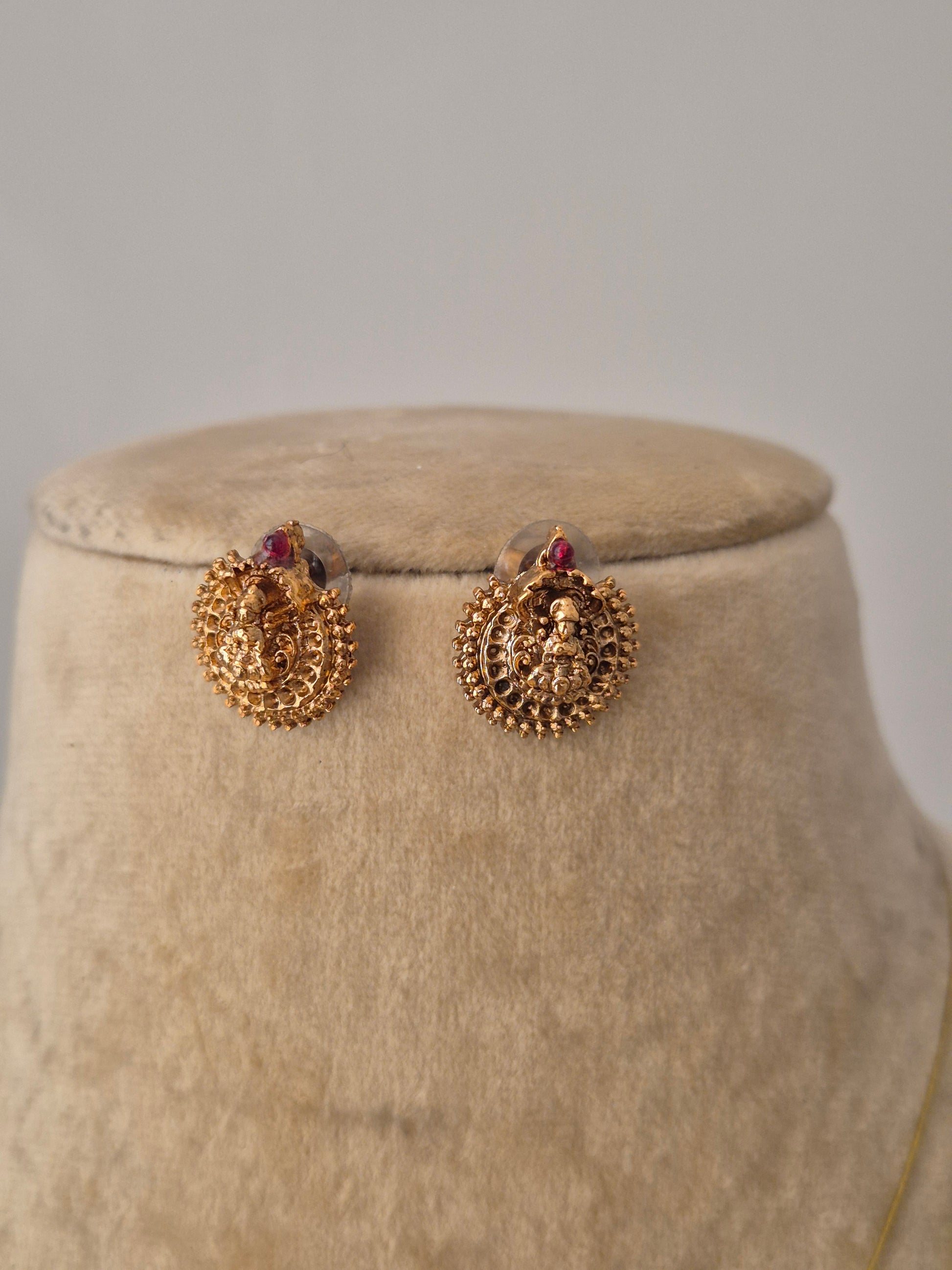 Traditional Indian-style Mayuri earrings in gold with small red stone, to showcase the modern ethnic  aesthetic by naitri.in