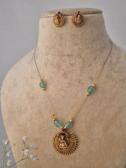 Artisanal gold-finish brass pendant necklace with green stone embellishments and matching studs from the Naitri collection by naitri.in