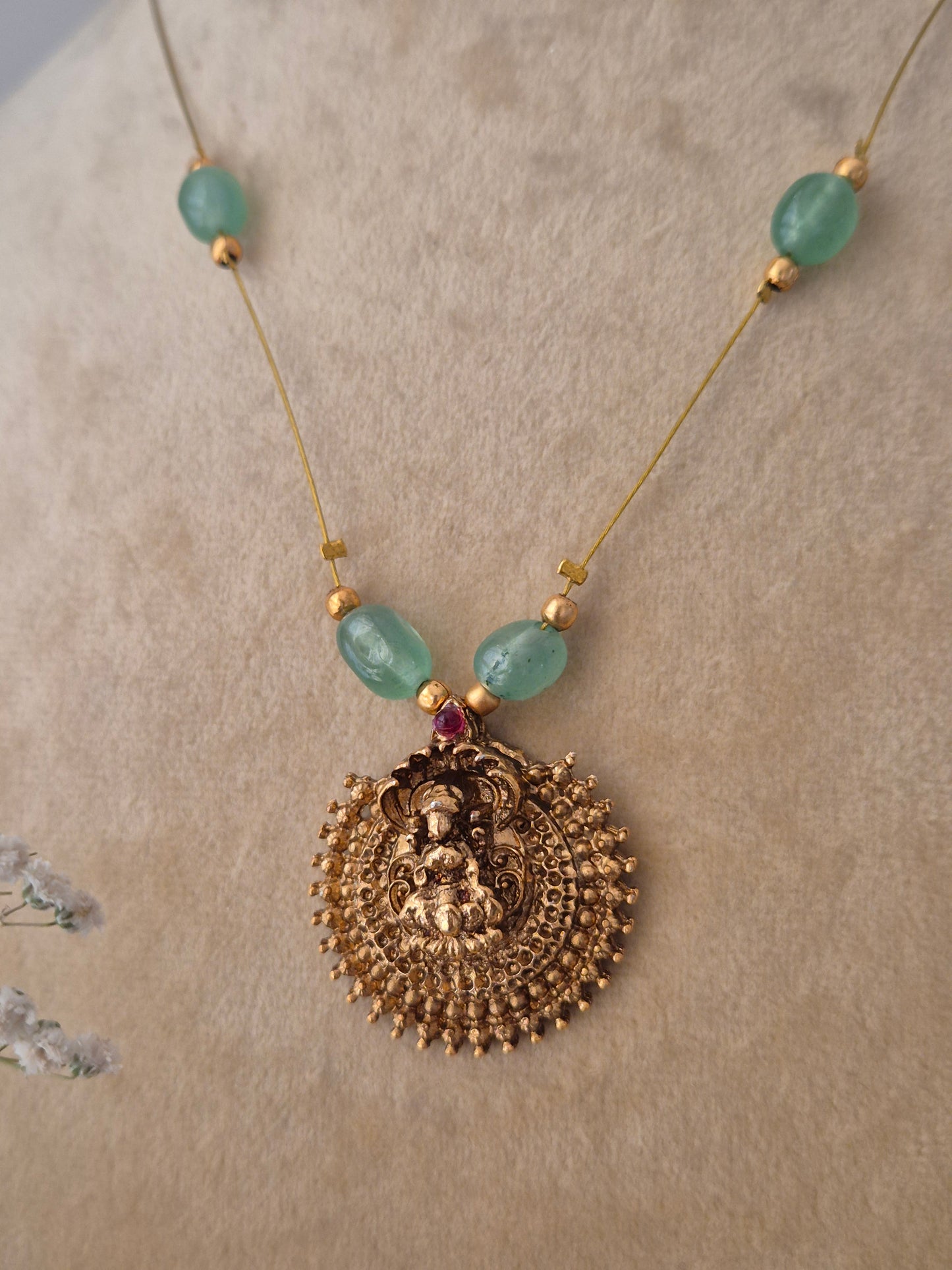 Handcrafted gold-polished necklace with five green gemstone beads and a large filigree pendant on a thin invisible chain, by naitri.in