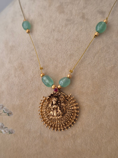 Handcrafted gold-polished necklace with five green gemstone beads and a large filigree pendant on a thin invisible chain, by naitri.in