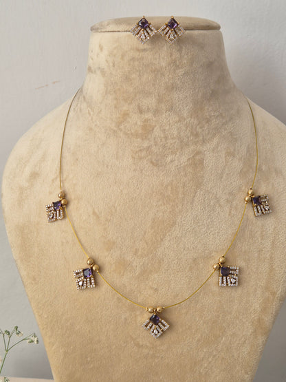 Modern Indian style gold chain necklace set with purple stone embellishments. Handcrafted delicate gold pendant necklace and earring set showcasing geometric crystal charms by naitri.in