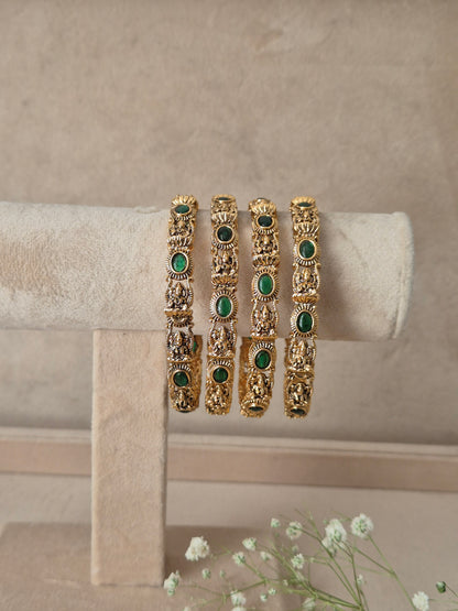 Meenal Bangles Set of 4 by Naitri featuring ethnic gold-plated traditional bangles with green stone embellishments for festive and wedding wear by naitri.in