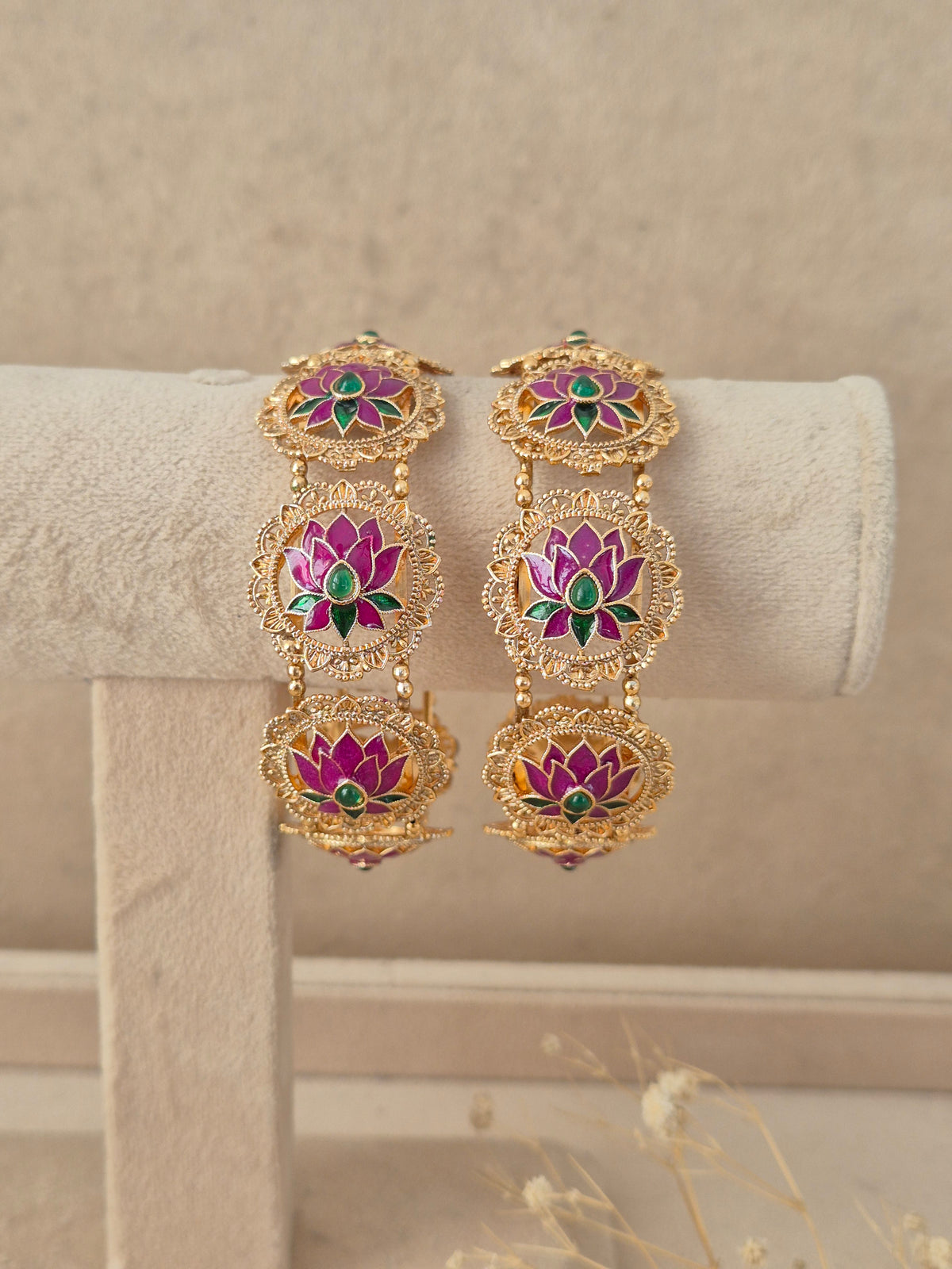 Set of 2 gold-plated bangles featuring circular lotus motifs inlaid with pink enamel petals and green stone accents, by naitri.in