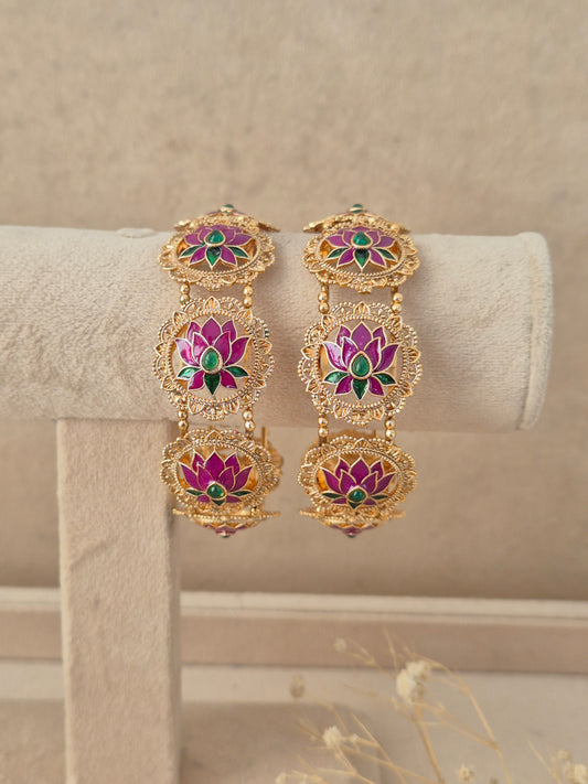 Set of 2 gold-plated bangles featuring circular lotus motifs inlaid with pink enamel petals and green stone accents, by naitri.in