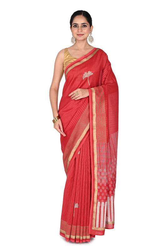 A woman wearing a vibrant red Meher hand block printed cotton-silk saree with white geometric patterns on the pallu and a gold zari border, paired with a sleeveless gold blouse by naitri.in