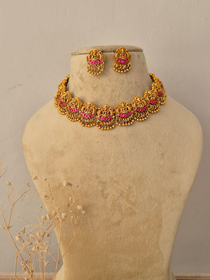 Meher Necklace Set featuring traditional gold temple motifs with vibrant ruby stone accents and matching earrings by Naitri.in