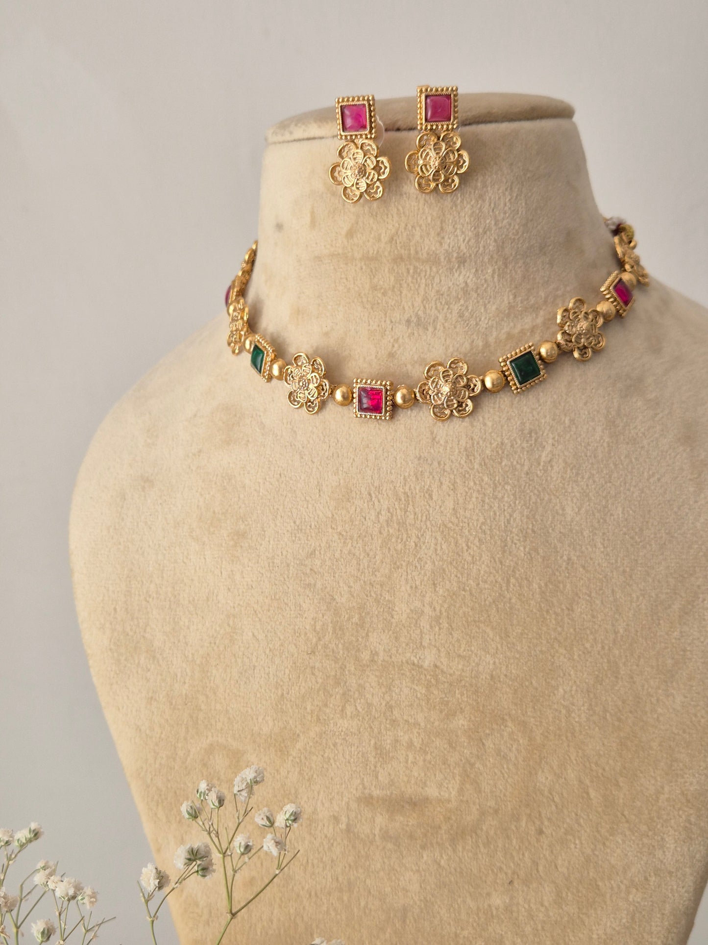 Traditional Indian floral necklace set with colorful stone accents and matching earrings by naitri.in