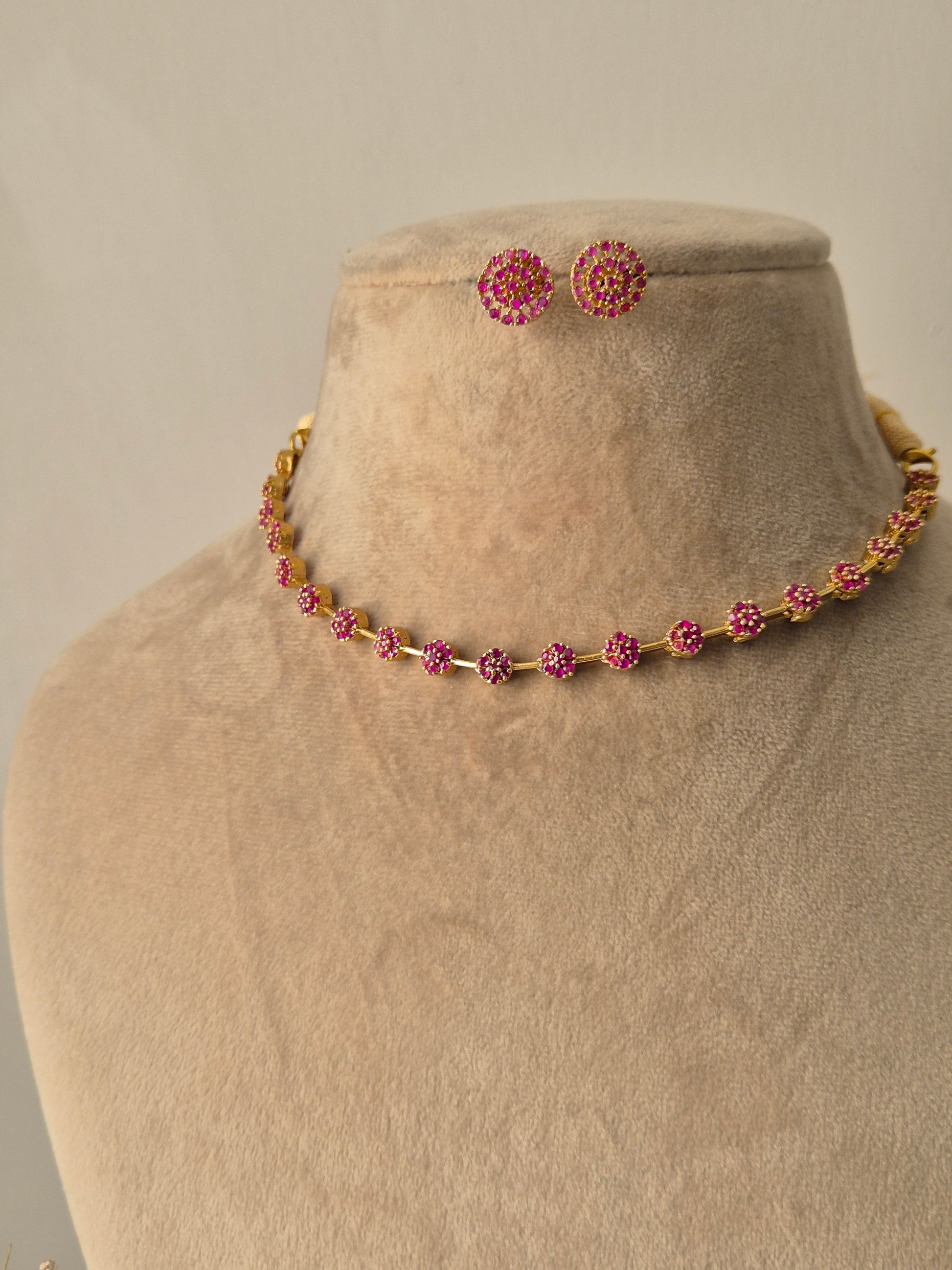 Minimalist Chameli gold necklace and earring set with green stones and floral motifs by naitri.in