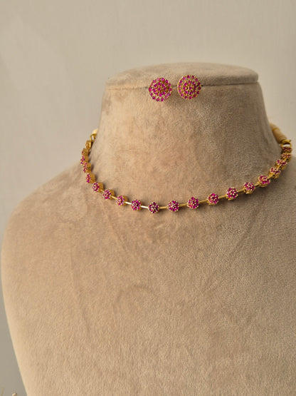 Minimalist Chameli gold necklace and earring set with green stones and floral motifs by naitri.in