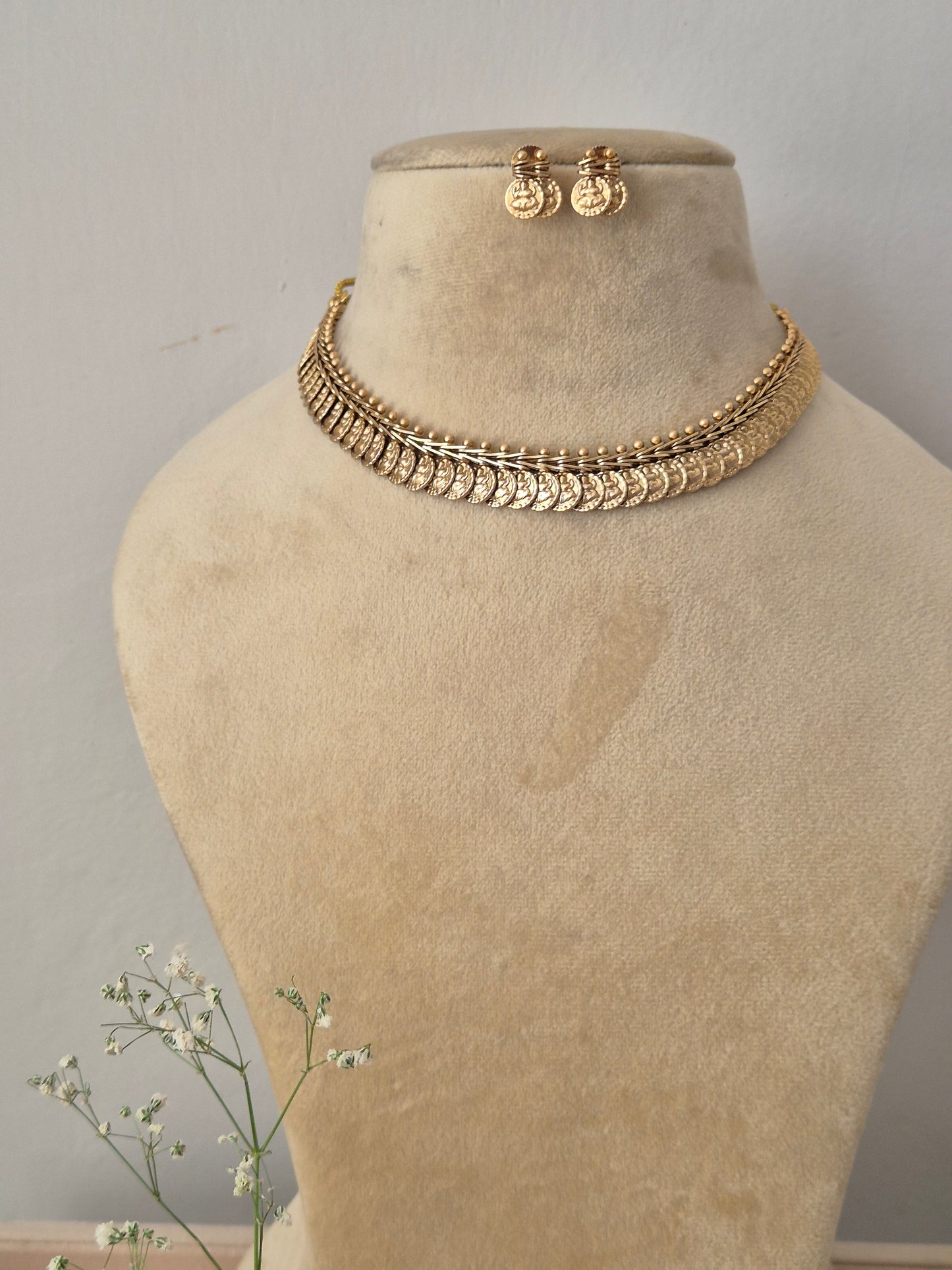 Antique gold choker necklace composed of overlapping coin charms and matching drop earrings by naitri.in