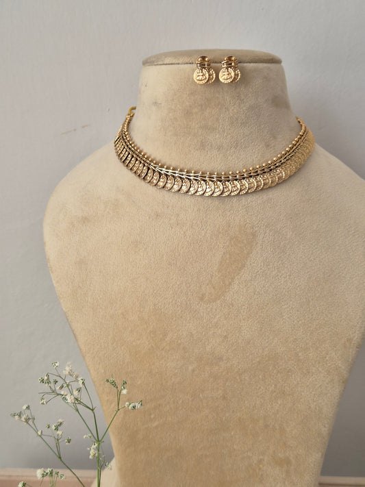 Antique gold choker necklace composed of overlapping coin charms and matching drop earrings by naitri.in