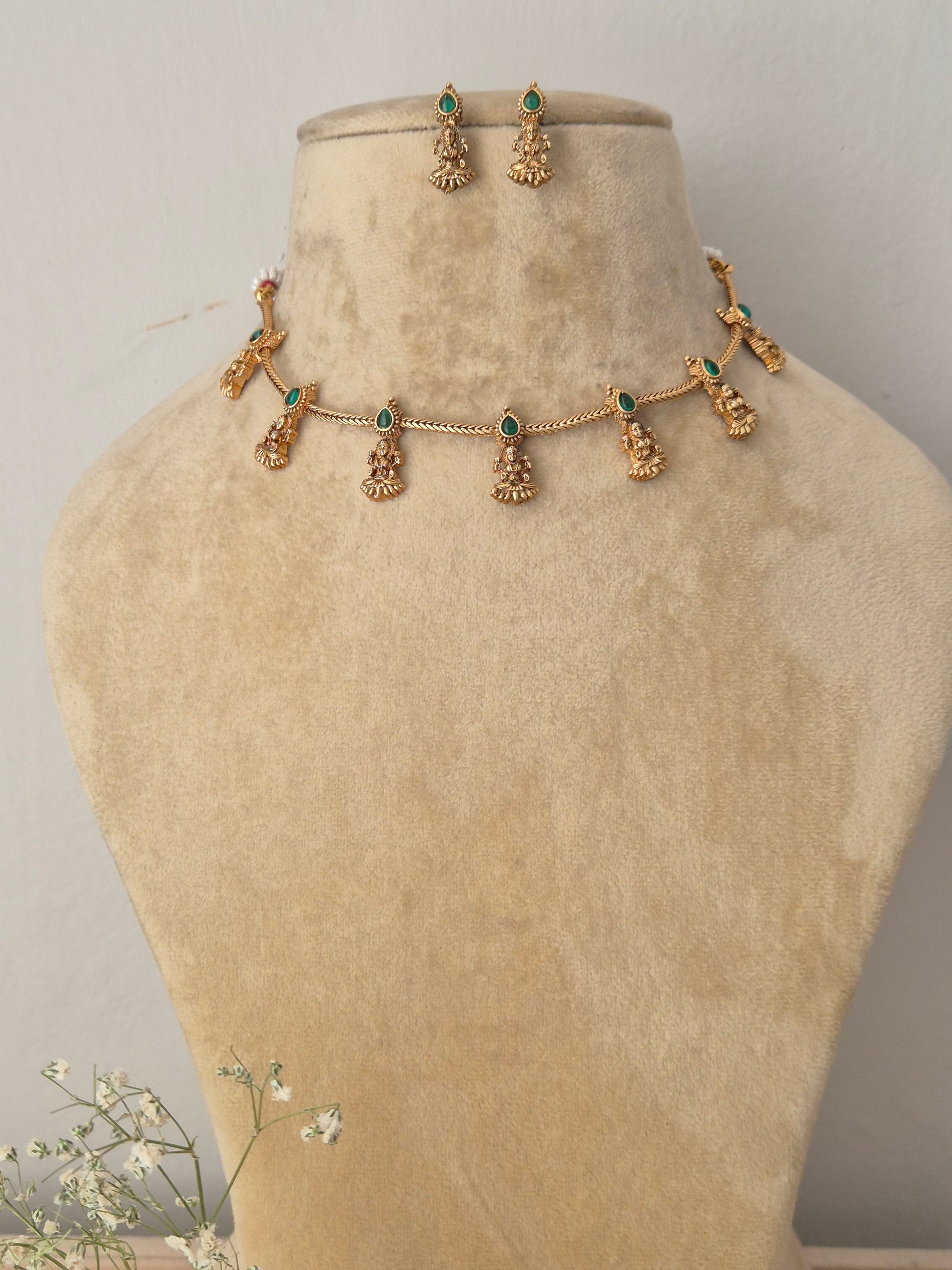 Gold choker necklace with green hanging deity charms and matching earrings by naitri.in