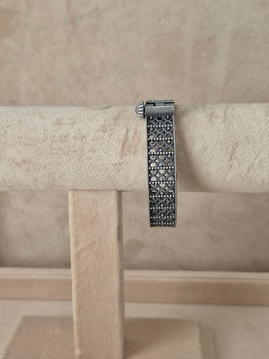 Antique silver oxidized Moana bangle featuring an intricate, deeply engraved floral and vine pattern, by naitri.in