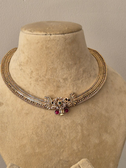 Antique gold-finish brass alloy necklace set with synthetic ruby and emerald embellishments for ethnic wear by naitri.in