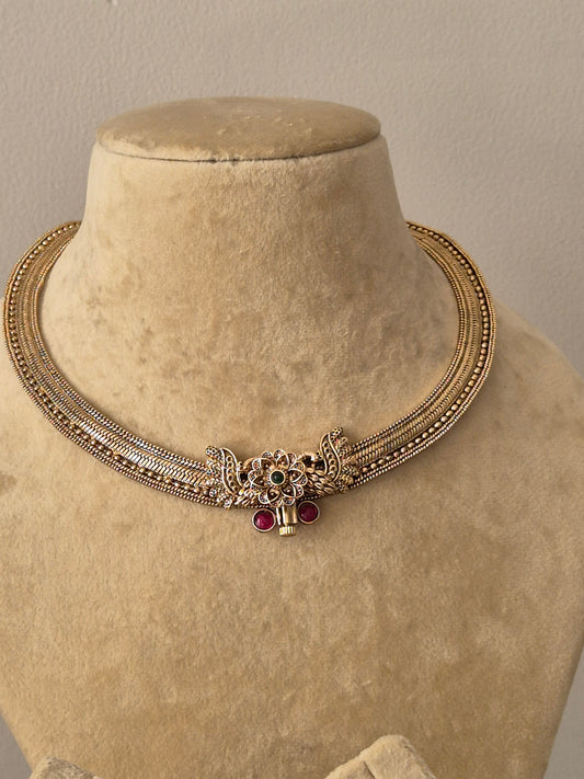 Antique gold-finish brass alloy necklace set with synthetic ruby and emerald embellishments for ethnic wear by naitri.in