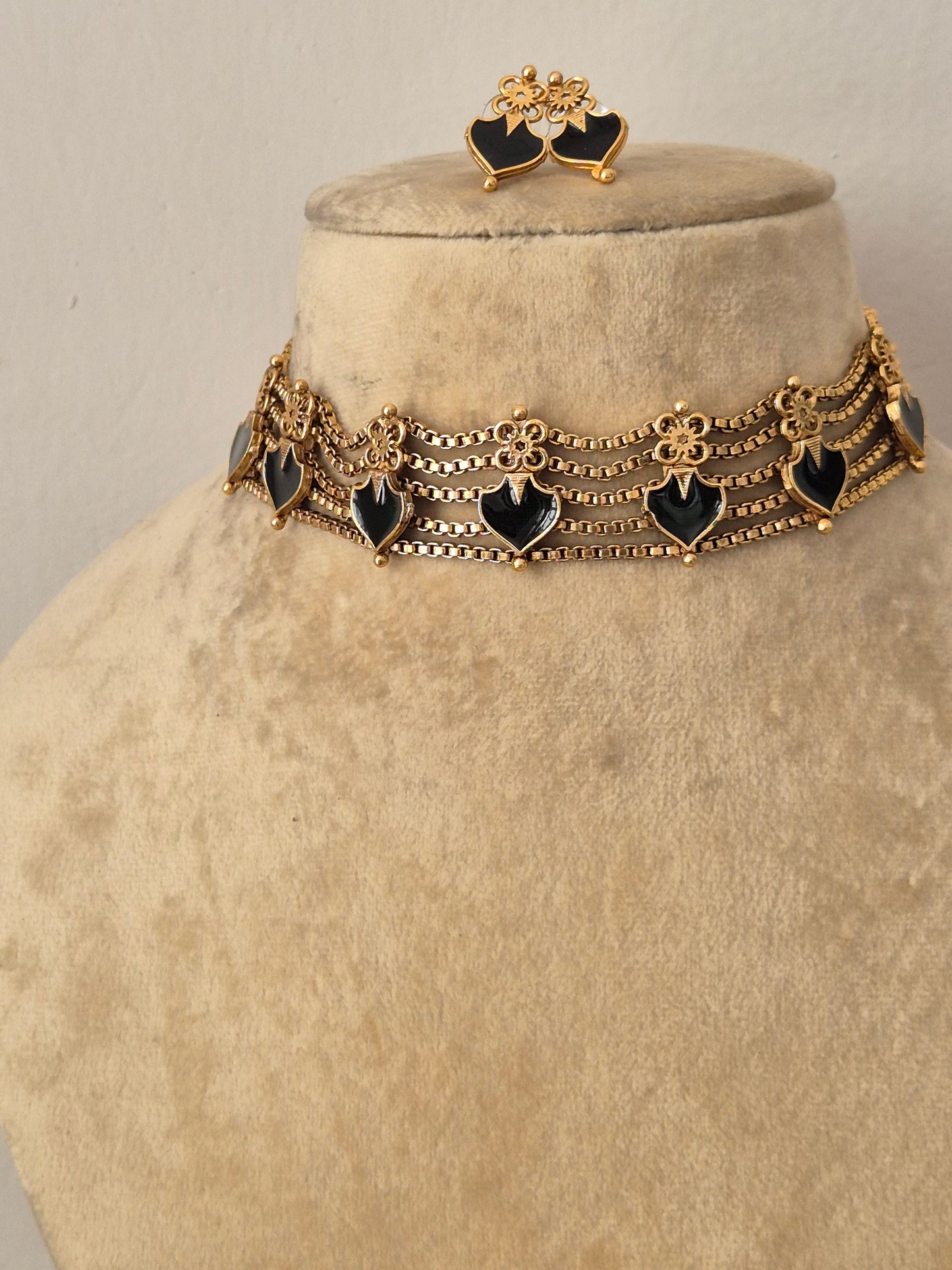 Modern Indian ethnic imitation jewelry set including a golden brass alloy choker necklace with delicate chain links and vibrant black heart motifs, by naitri.in