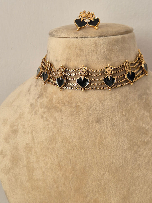 Modern Indian ethnic imitation jewelry set including a golden brass alloy choker necklace with delicate chain links and vibrant black heart motifs, by naitri.in
