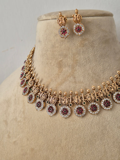 Gold-plated Indian ethnic choker set featuring a textured band with delicate hanging coin-shaped charms accented by a halo of small white crystals, alongside matching stud earrings by naitri.in