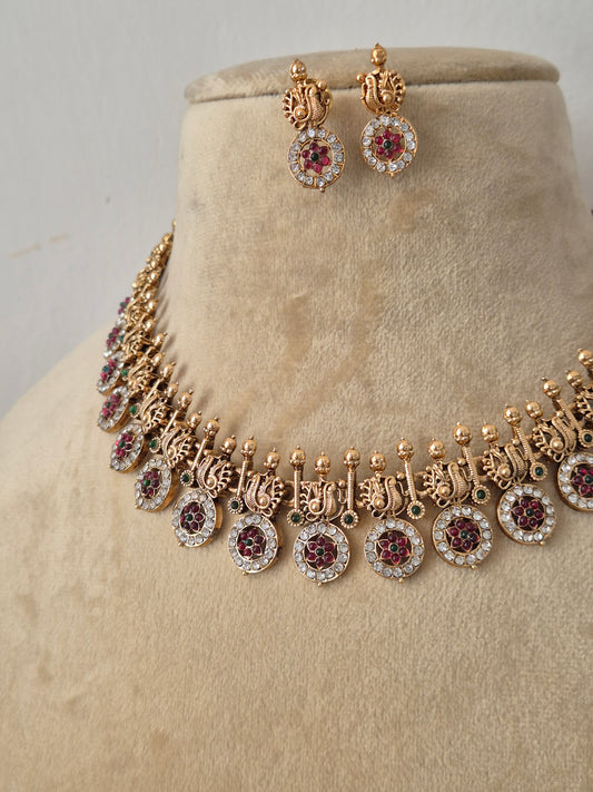 Gold-plated Indian ethnic choker set featuring a textured band with delicate hanging coin-shaped charms accented by a halo of small white crystals, alongside matching stud earrings by naitri.in