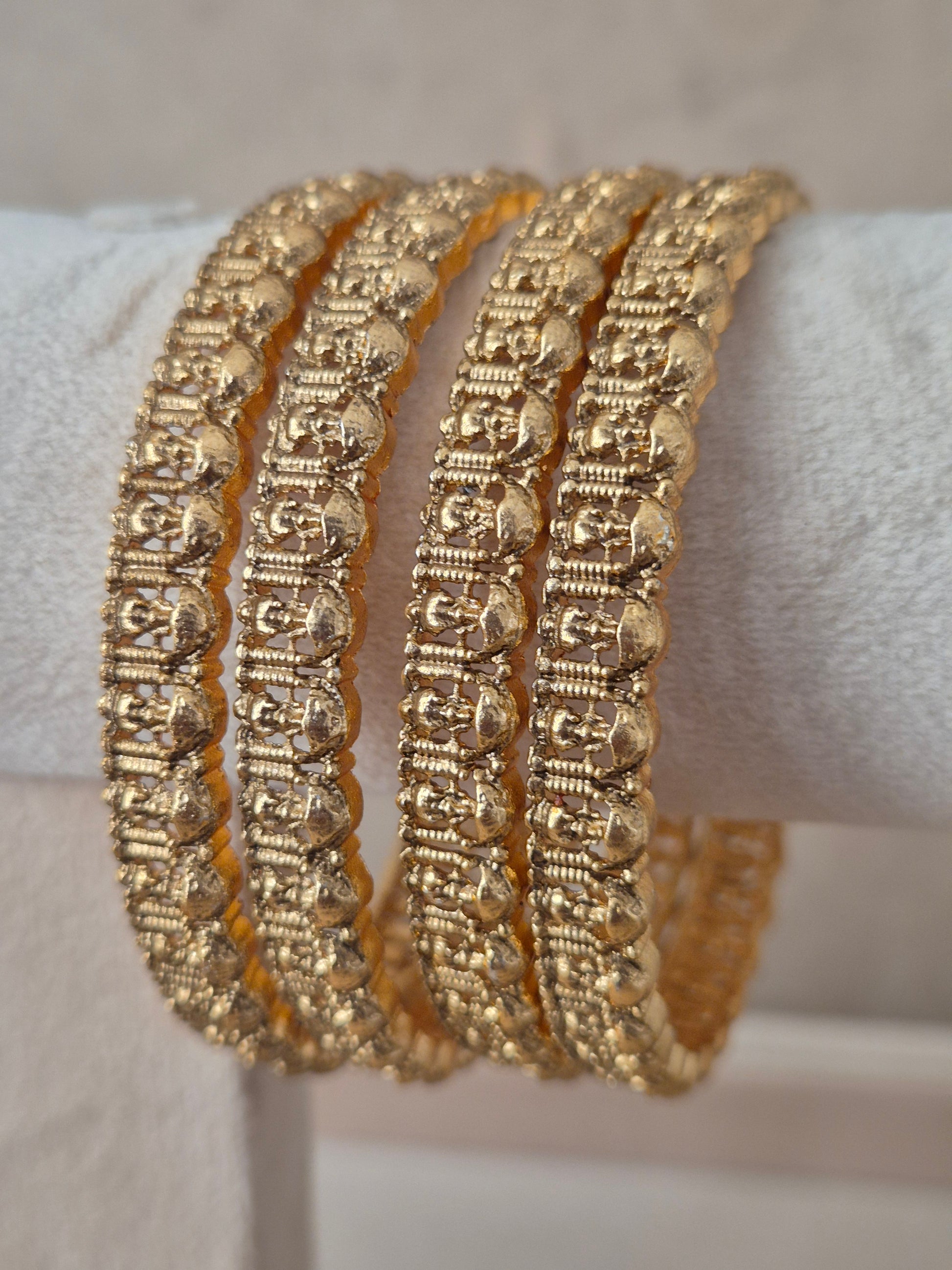 Four traditional gold-plated ethnic bangles with detailed geometric patterns by naitri.in