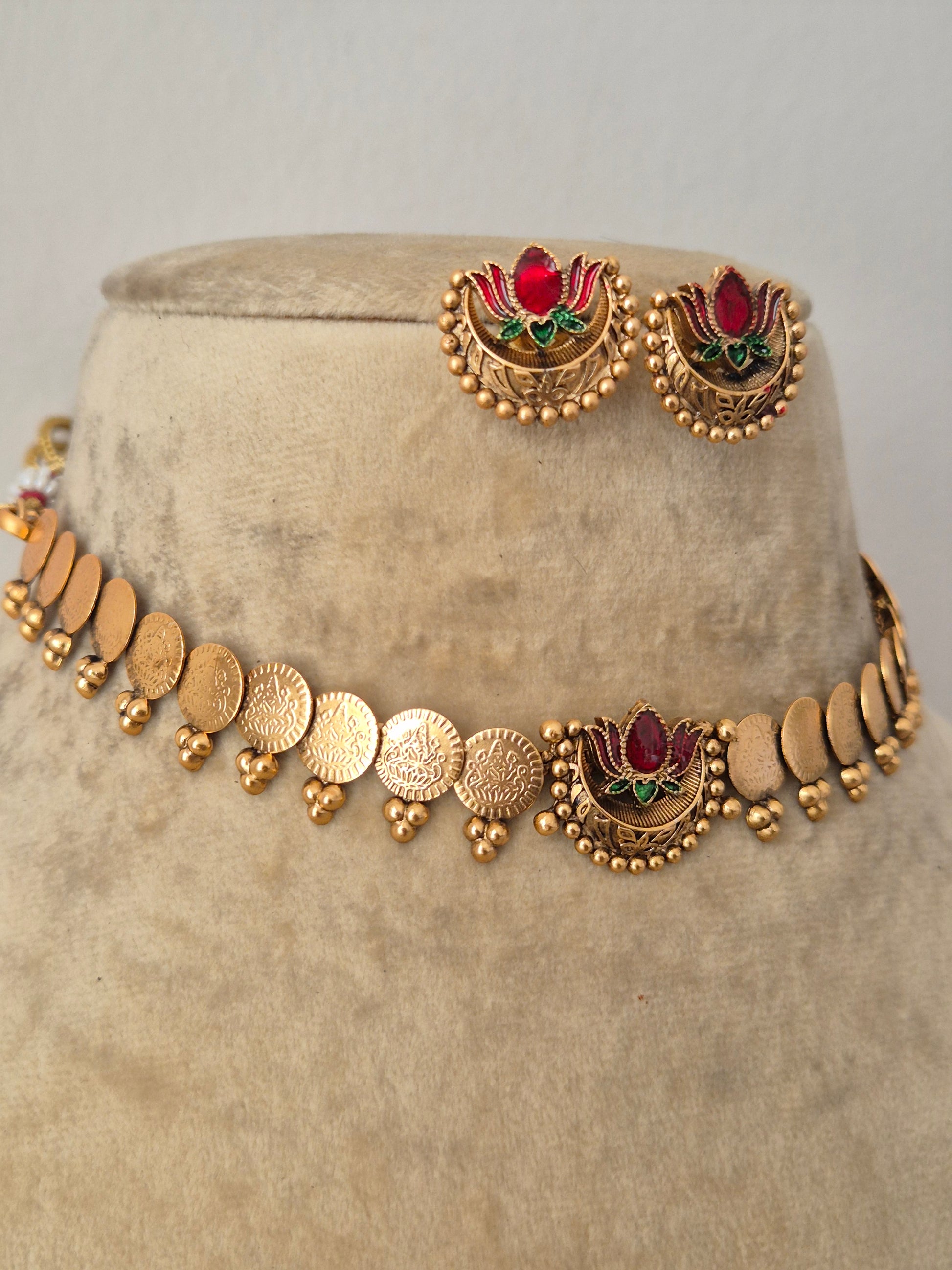 Modern Indian ethnic imitation jewelry set including a golden brass alloy choker with traditional coin details and a vibrant enamel lotus centerpiece by naitri.in